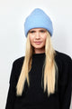 Model wearing light blue knit cuffed beanie and black sweater