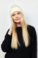 Model wearing ivory knit cuffed beanie looking at camera