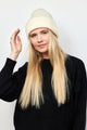 Model wearing ivory knit cuffed beanie and black sweater