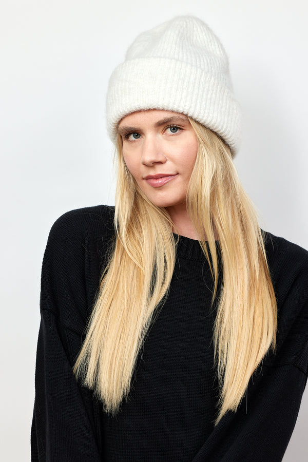 Model wearing ivory ribbed knit beanie