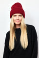 Berry red ribbed knit beanie on model wearing black sweater