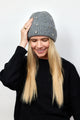 Model wearing black sweater and grey ribbed beanie with crystal embellishments