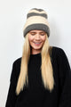 Grey and ivory striped ribbed knit cuffed beanie on model wearing black sweater