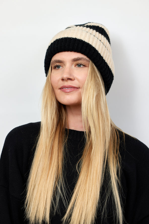 Black and ivory striped ribbed knit cuffed beanie on model with blonde hair