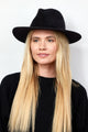 Model wearing black velour brimmed hat