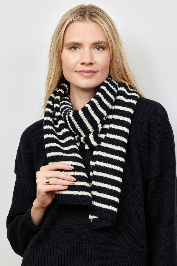 Model holding Black and ivory ribbed striped scarf around her neck