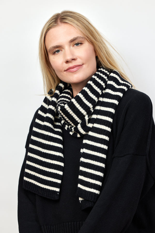 Black and ivory ribbed striped scarf on model in black sweater