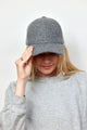 Model holding brim of grey wool blend baseball cap