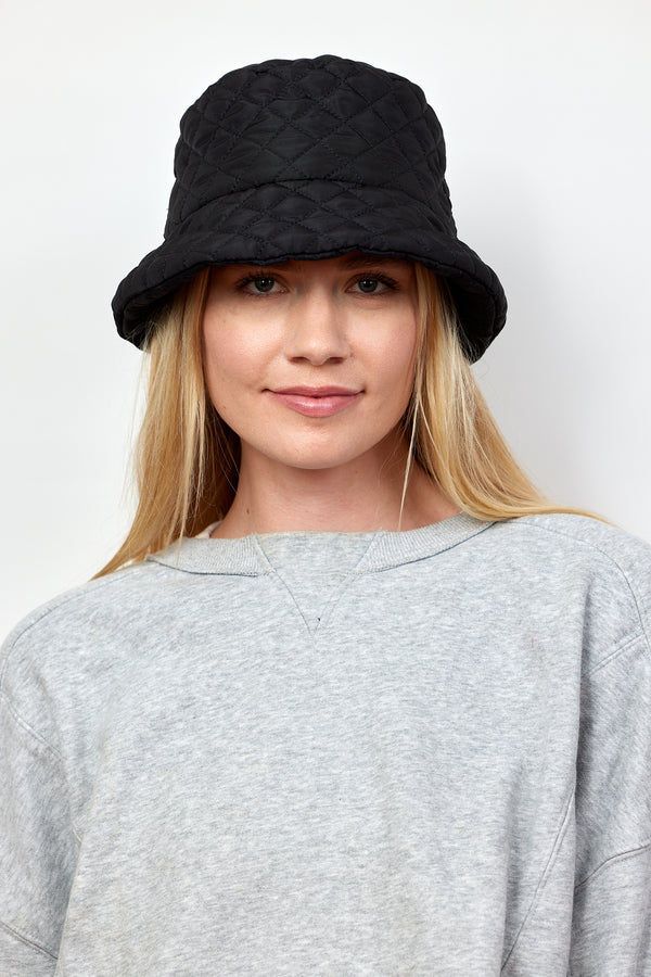 Model wearing black quilted bucket hat with faux fur lining and grey sweatshirt