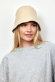 Model wearing tan knit bucket hat and grey sweatshirt