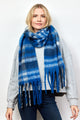 Model wearing blue and ivory plaid scarf with fringe detail with her arms by her side