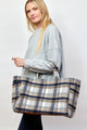 Model holding blue and brown plaid tote