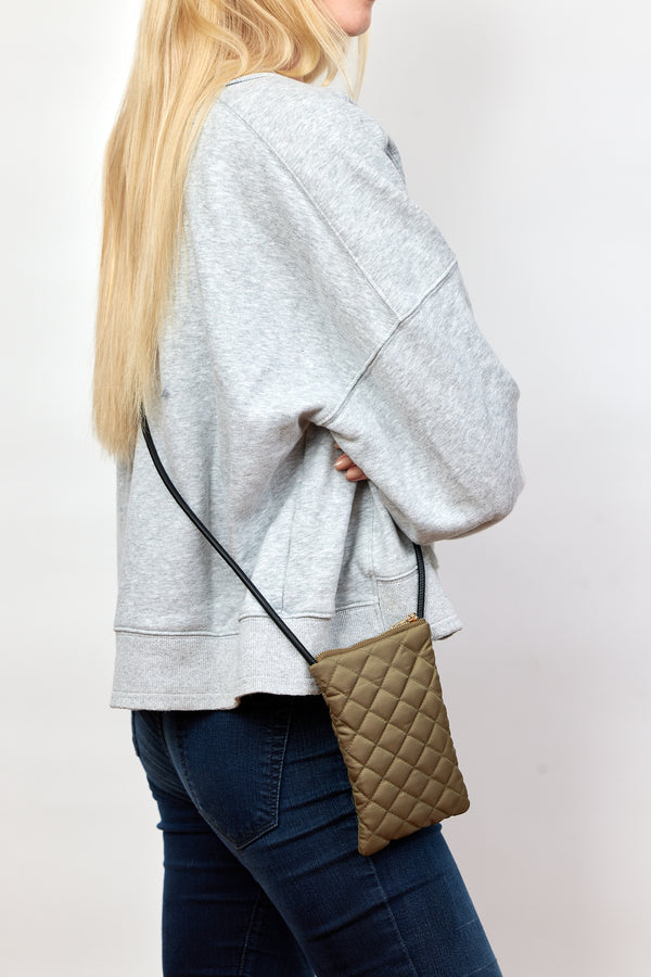 Model wearing olive quilted phone bag with crossbody strap