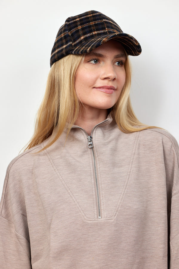 Model wearing dark plaid cap