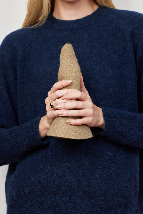 Model holding camel brown velour brimmed hat rolled up