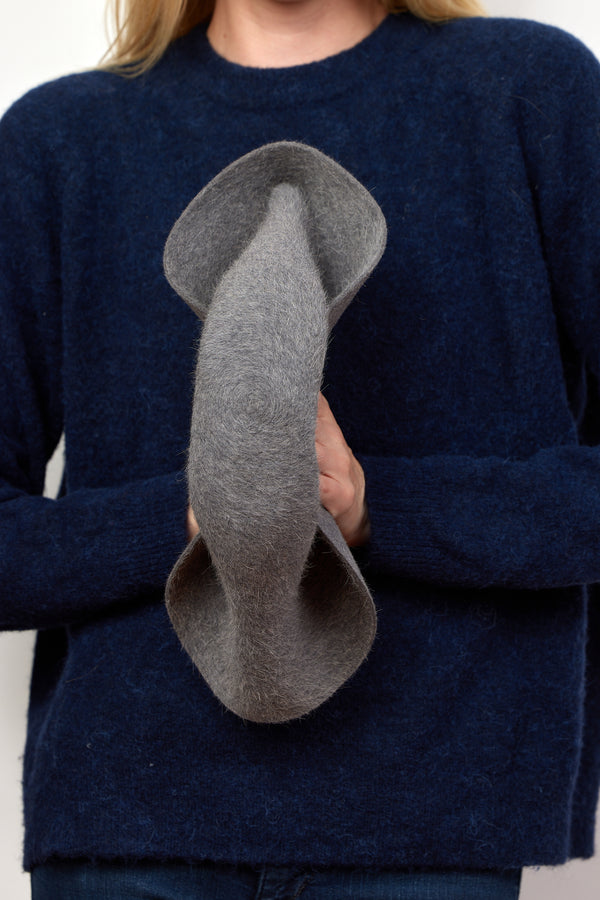 Model showing how grey velour brimmed hat is packable