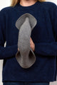 Model showing how light grey velour hat is packable