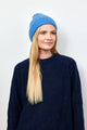 Denim blue cashmere rib beanie on model wearing navy blue sweater