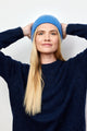 Denim blue cashmere rib beanie on model with arms on head