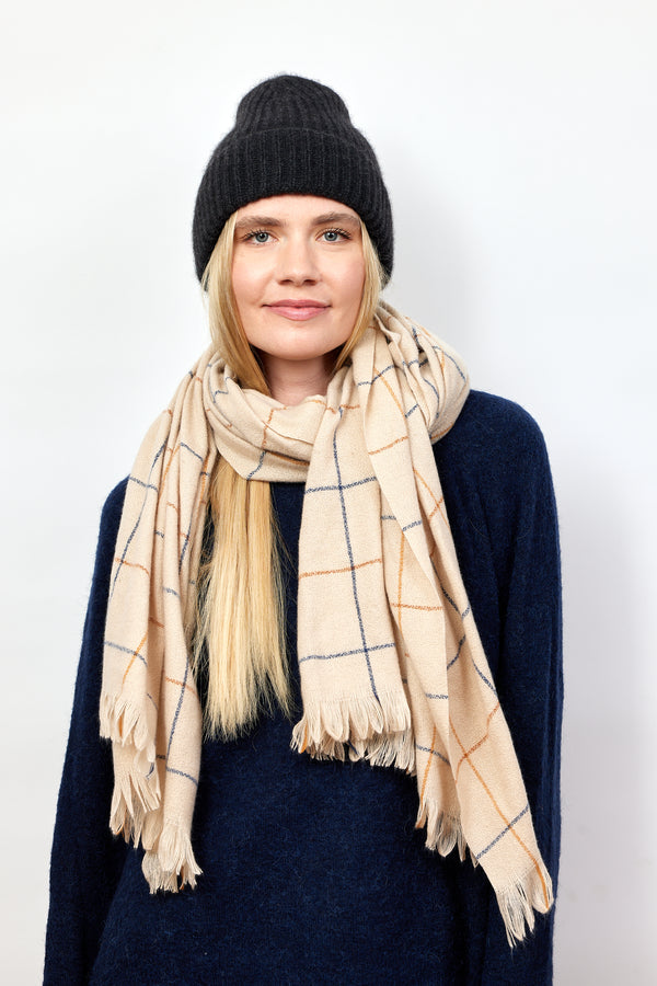 Model wearing ivory scarf with large check patten