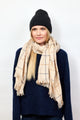 Black beanie and ivory scarf with large check pattern on model