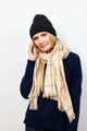 Black cashmere beanie on model wearing tan check scarf