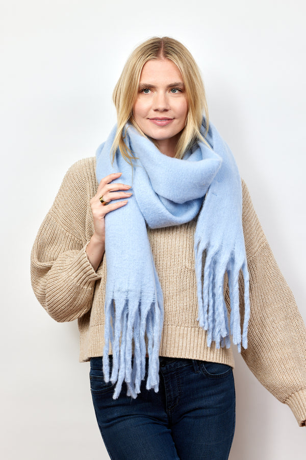 Light blue solid scarf with fringe on model