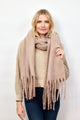 Model holding taupe solid scarf with fringe around her neck