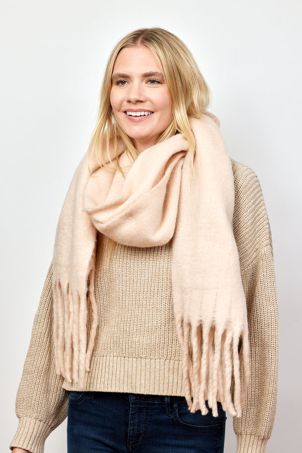 Blush pink solid scarf with fringe on smiling model