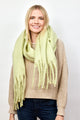 Model smiling while wearing mint green solid scarf with fringe