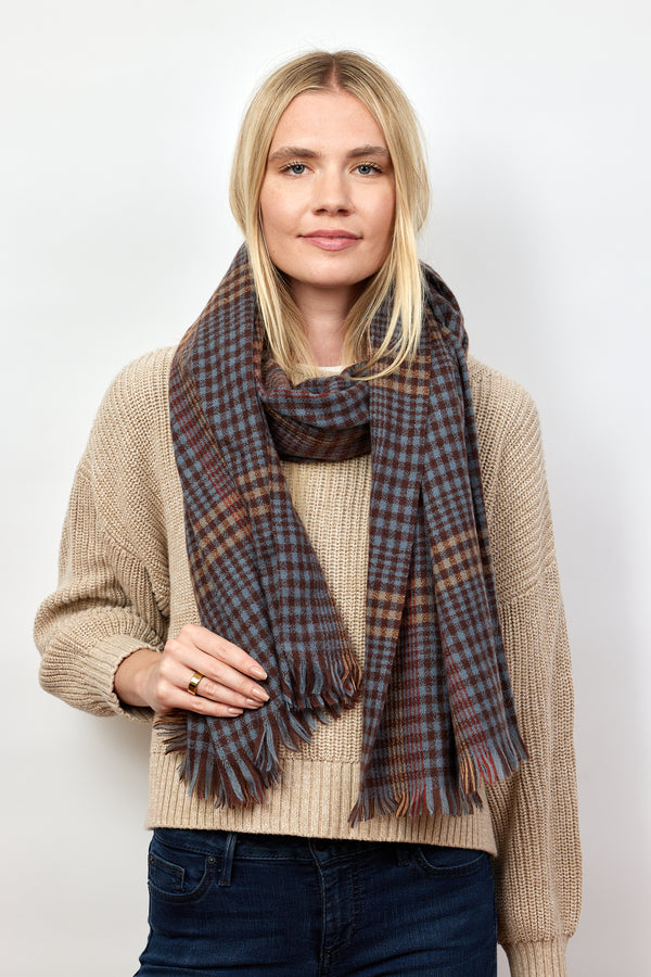 Model holding and wearing brown and blue check pattern scarf