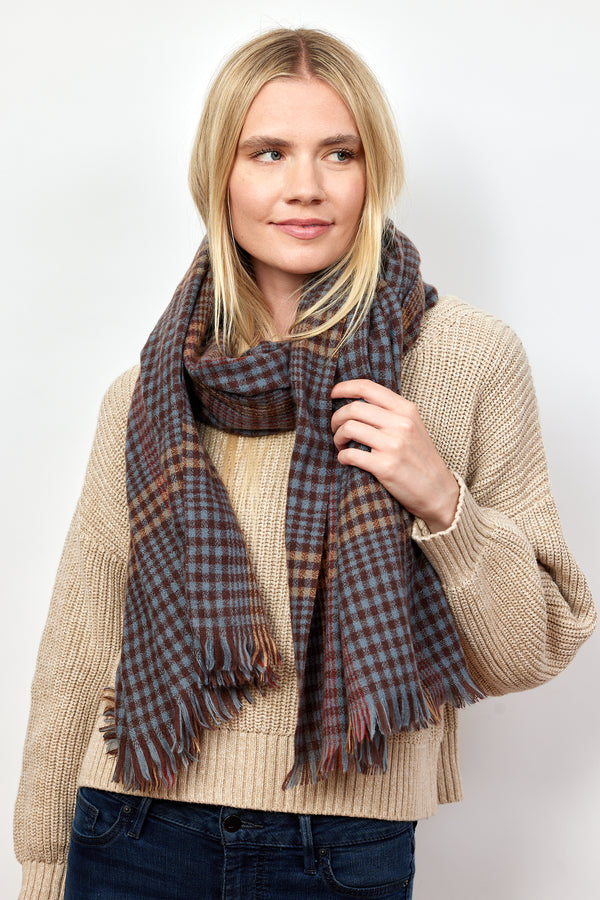 Model wearing brown and blue check pattern scarf