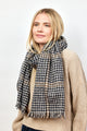 Model wearing black and tan herringbone scarf with tan sweater