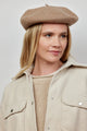 Model looking to her left while wearing taupe wool felt beret