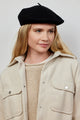 Model looking to her left while wearing black wool felt beret