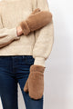 Model wearing taupe faux fur mittens and ivory sweater