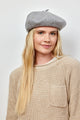 Model wearing grey beret with crystal embellishments