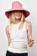 Model wearing pink canvas sun hat with chinstrap and white tank top