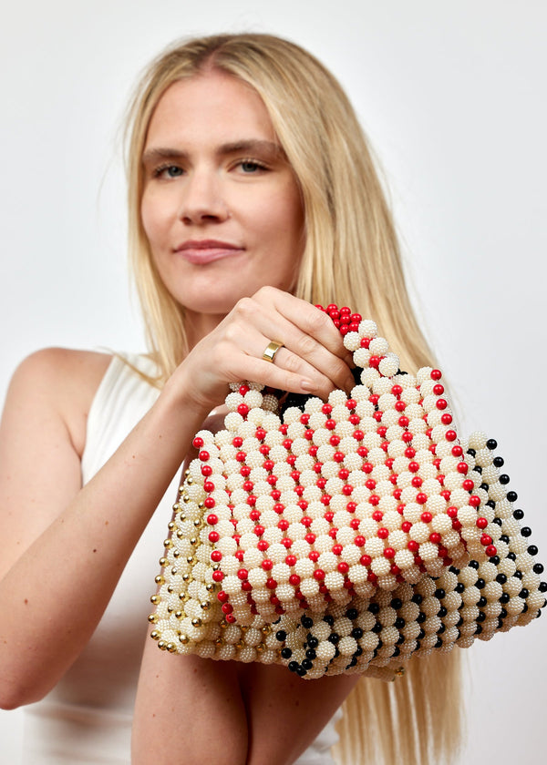 Model holding 3 beaded bags