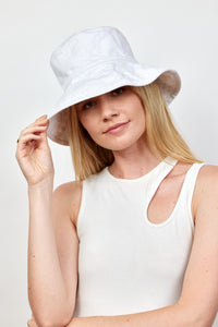 Model holding brim of white cotton bucket hat