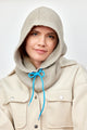 Model wearing tan balaclava with blue drawstring on her head