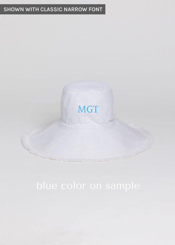 White canvas bucket hat with fringe and blue embroidered letters
