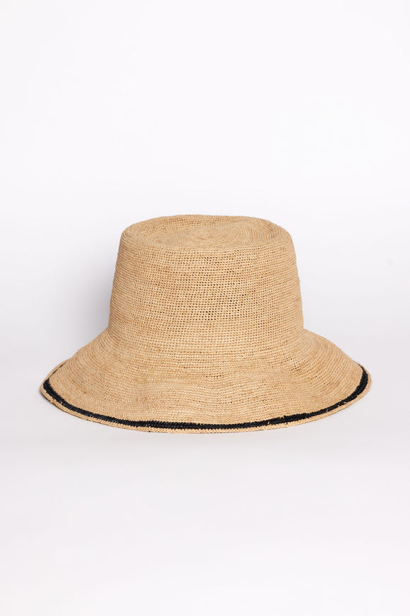 Beige straw bucket hat with black trim on a white background