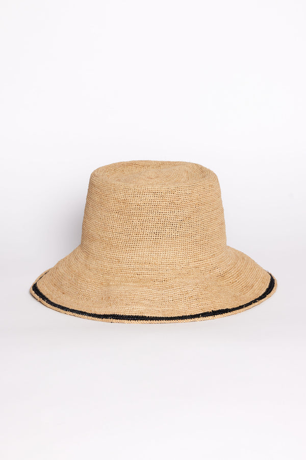 Beige straw bucket hat with black trim on a white background
