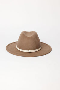Brown fedora hat with a white band on a light beige background