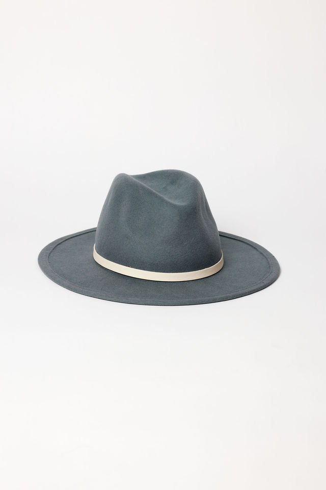 Blue fedora hat with a white band on a light gray background