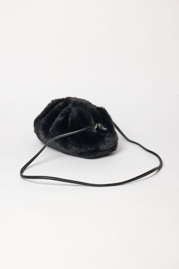 3/4 angle of black faux fur clutch with strap
