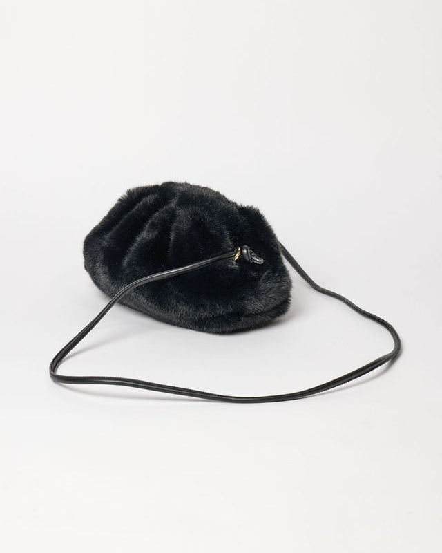 3/4 angle of black faux fur clutch with strap