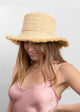Packable Raffia Bucket Hat with fringe trim on model in pink dress