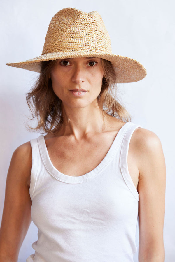 Woman wearing a straw hat against a white background